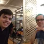 Two Wolsey Hall Oxford students at a table with glasses, one smiling at the camera and the other looking forward.