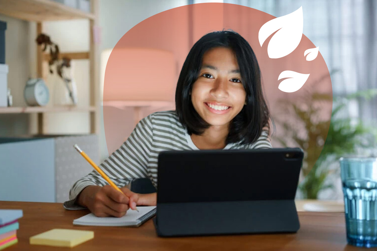 A homeschooling female student with short black hair studying at her bedroom desk, smiling at the camera.
