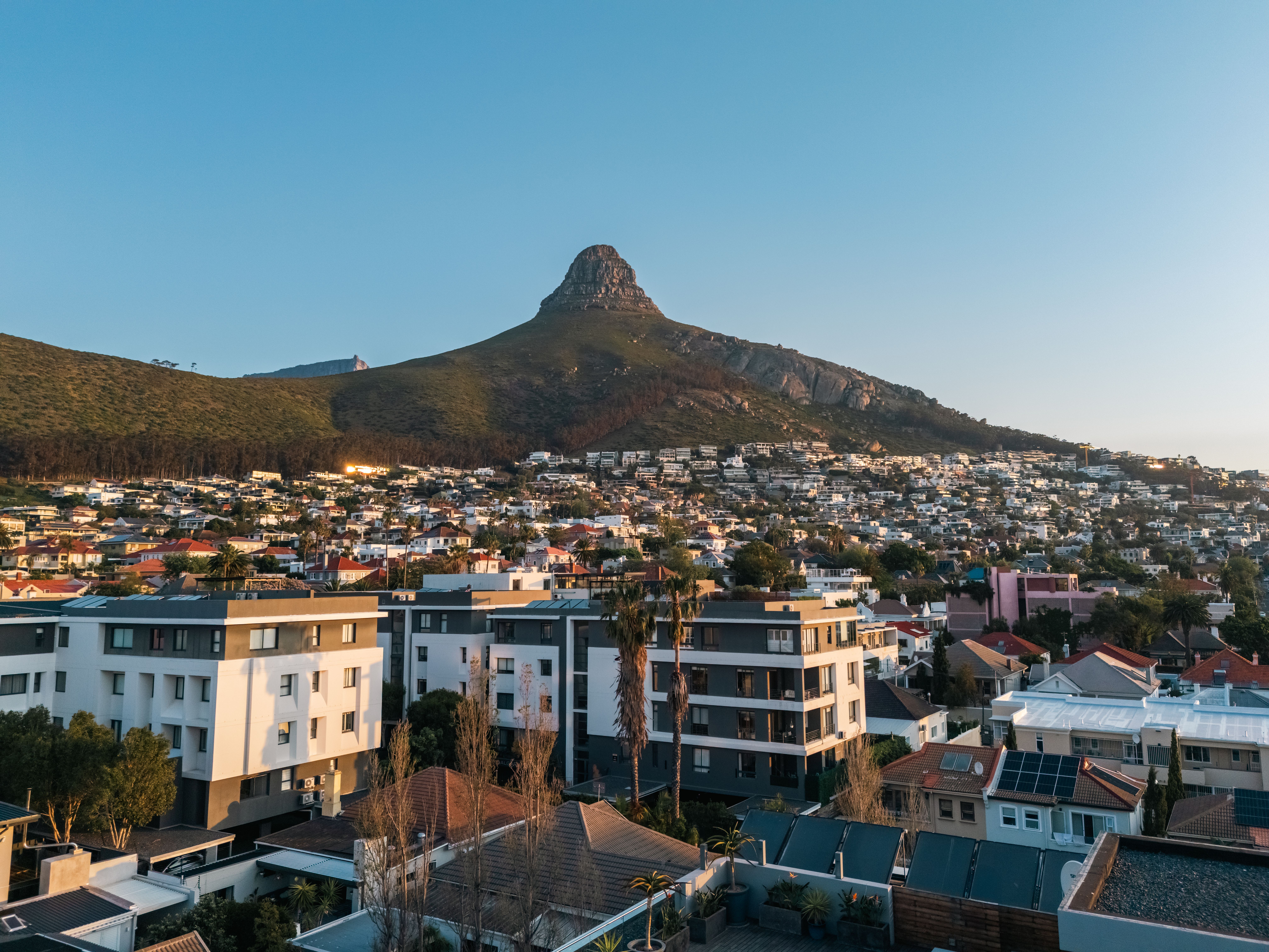 Cape Town suburb with Lion’s Head mountain in the background under a clear evening sky.