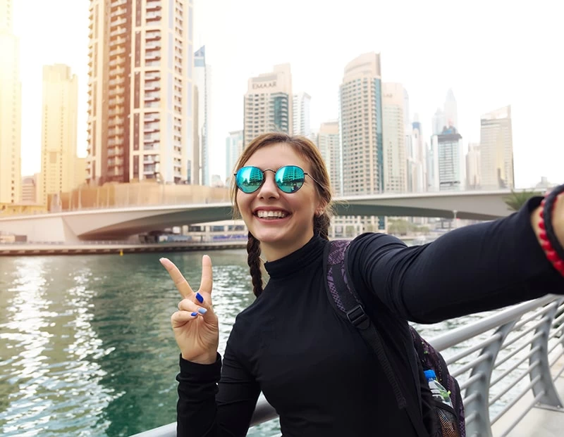Smiling teenage student taking a selfie in a modern UAE city, symbolising flexible, student-led learning
