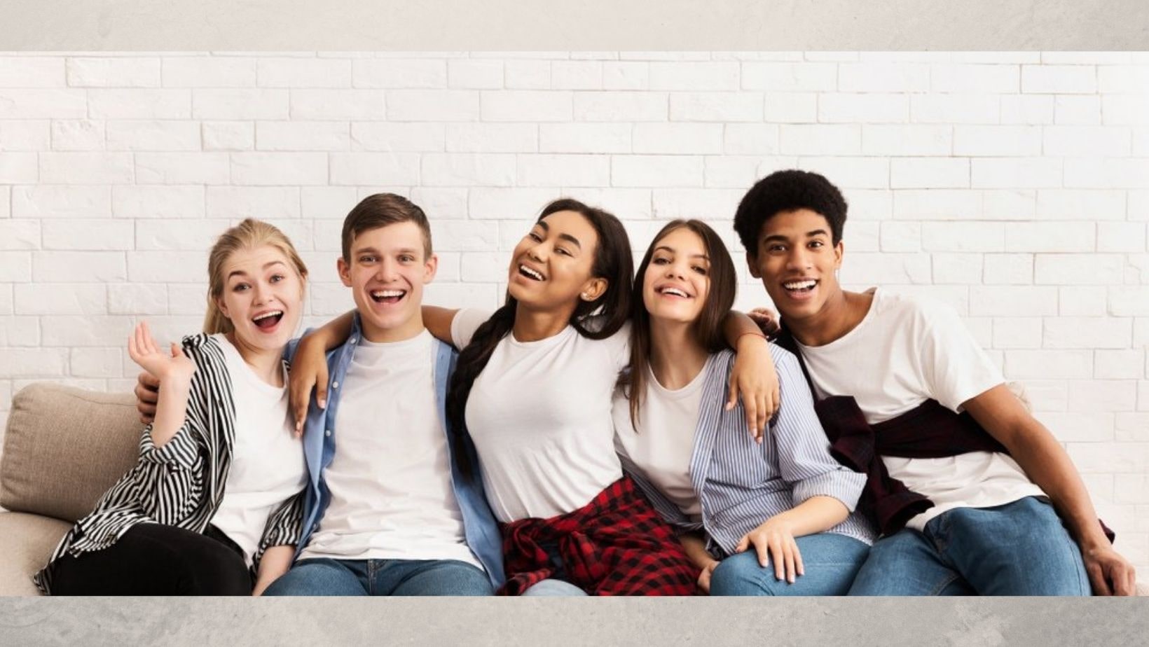 A Level age students sat together arm in arm, smiling. 