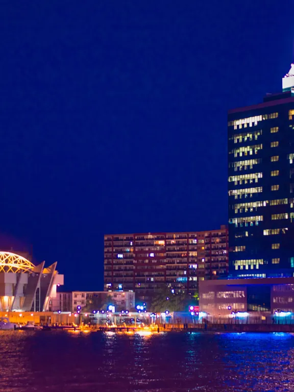 A landscape view of a Nigerian city's skyline at night, lit up by building and street lights.