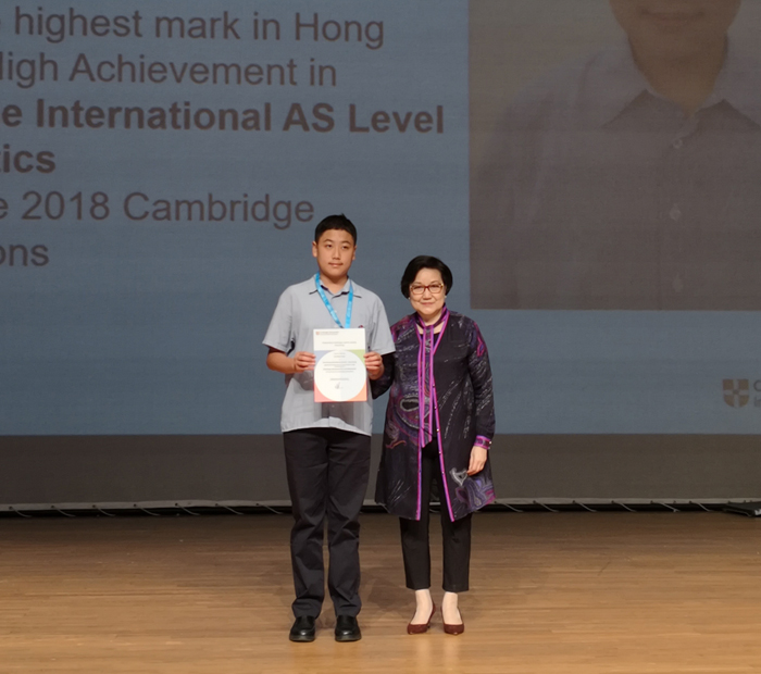 Wolsey Hall Oxford student Victor stands with his mother after being awarded Outstanding Cambridge Learner Award.