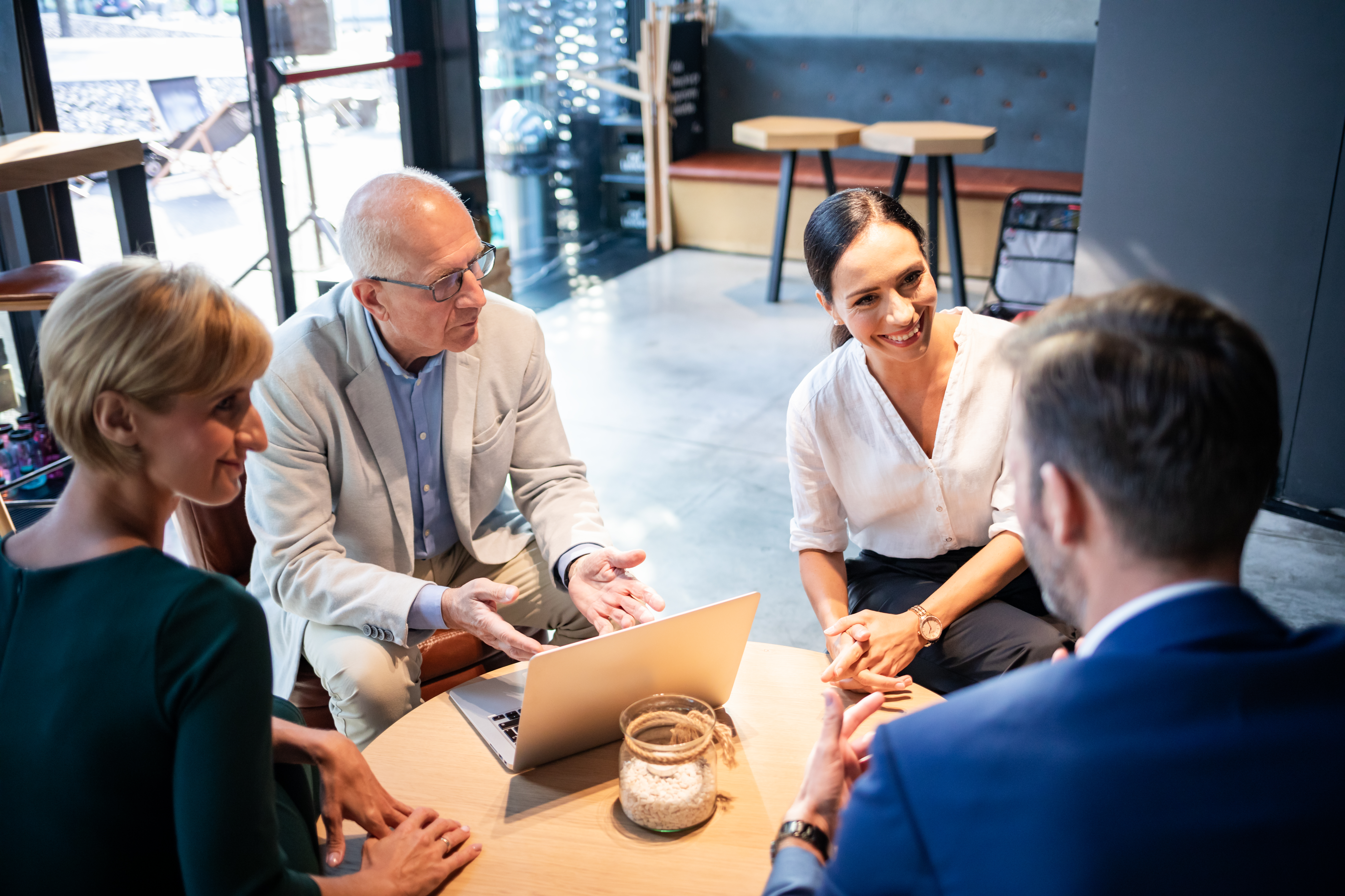 Four professionals having a collaborative meeting in a modern workspace.