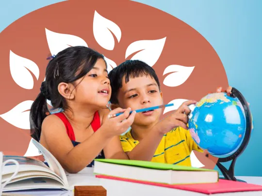 Young boy and girl looking at a globe and pointing out locations, surrounded by books