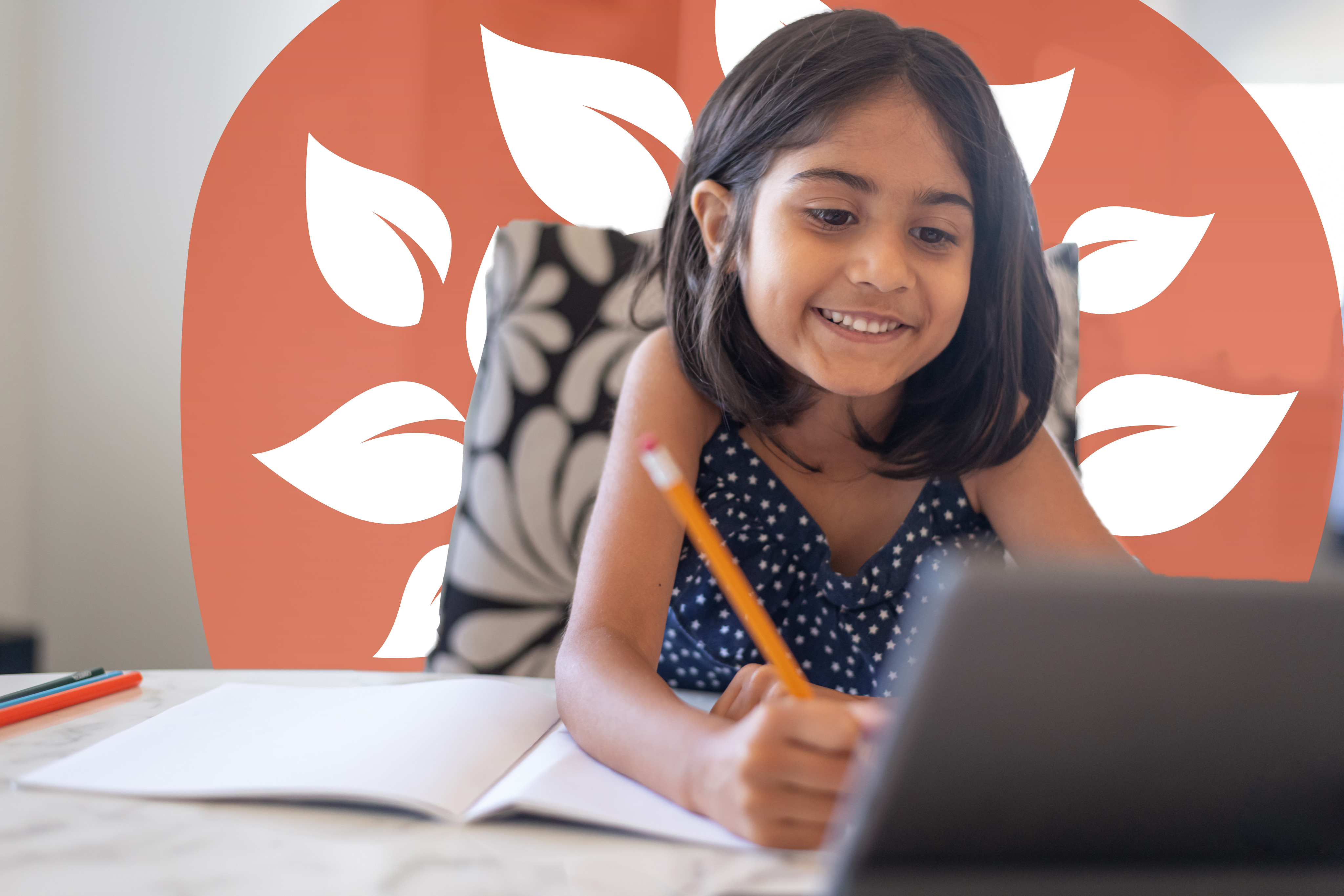 A young student smiling and writing in a notebook while looking at a tablet, with a leafy design in the background.