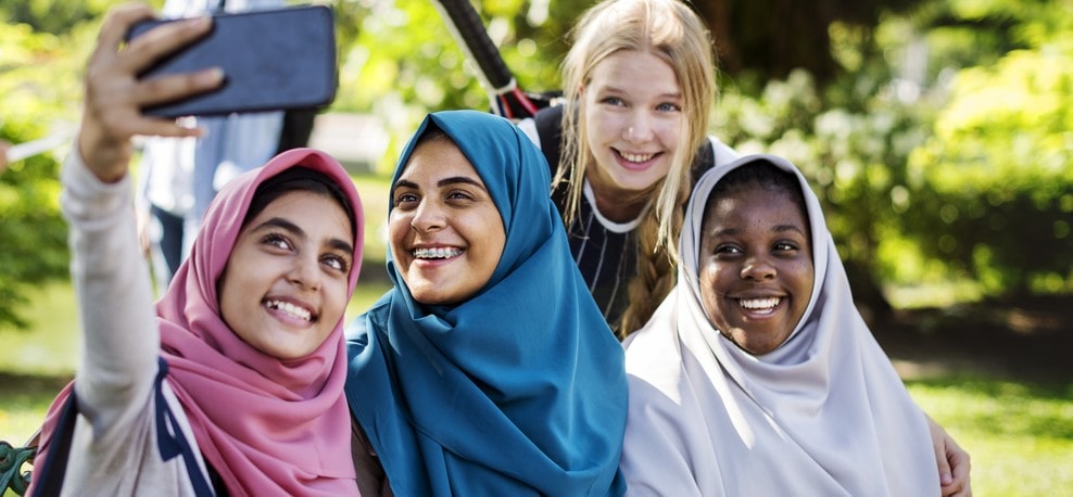 Highlighting the vibrant social life of homeschoolers in Sharjah: teenage friends taking a happy selfie together.