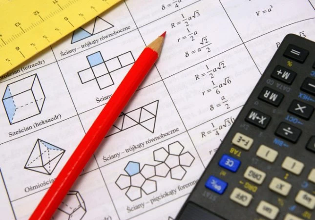A maths problem sheet with a pencil and calculator on top of it. 