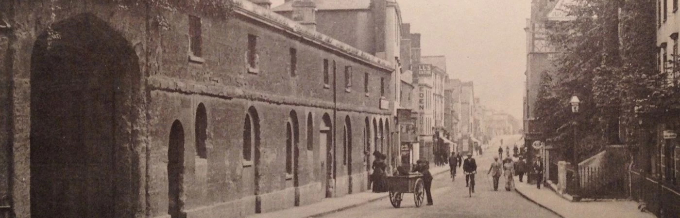 An old sepia landscape photograph of a historic street scene.