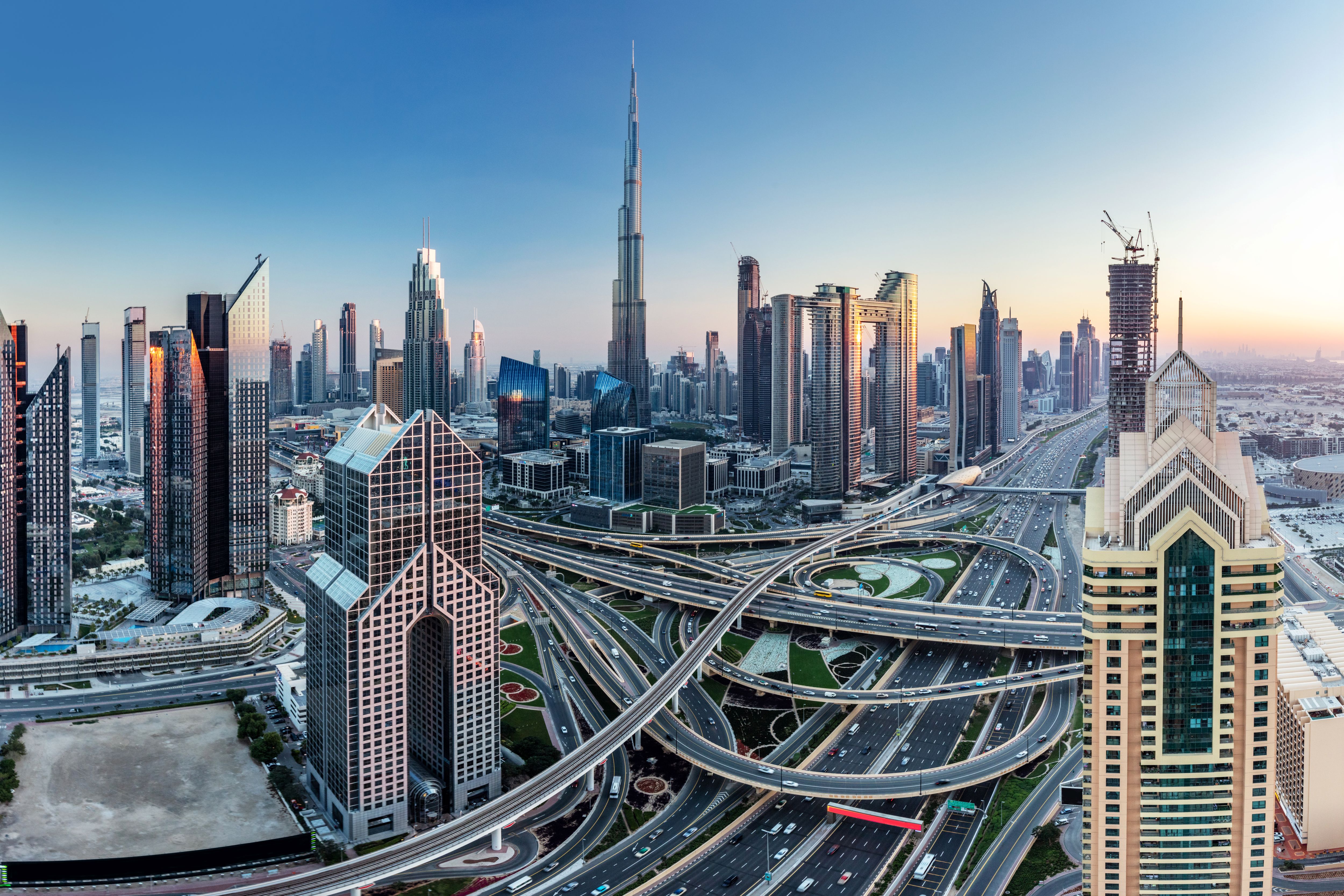 Modern skyline of Dubai with Burj Khalifa and network of motorways at sunrise