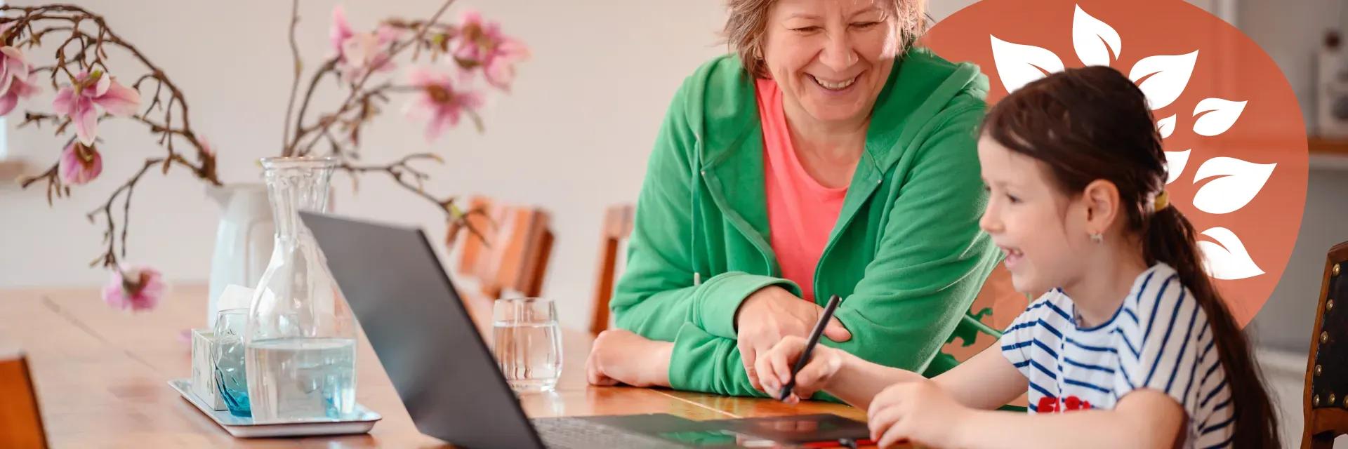 Young girl enjoying a learning activity at home with older adult and laptop