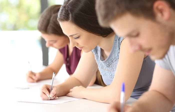 Three A Level students making notes on what they're studying. 
