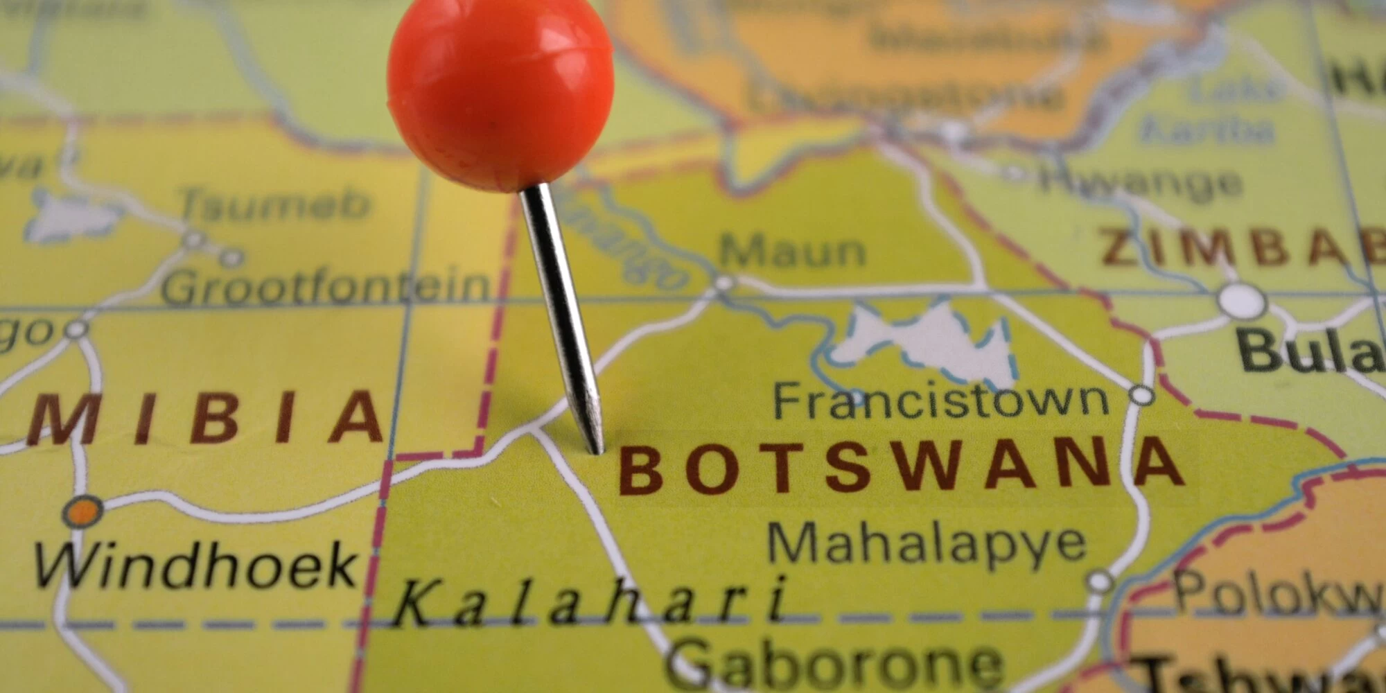 Close up of a map, with a pin in the country of Botswana. 
