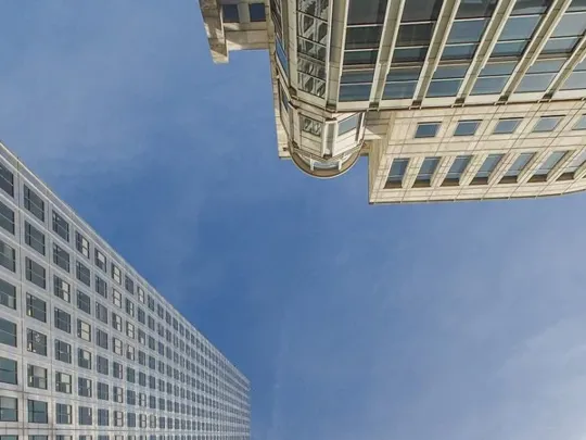 Looking towards the sky surrounded by high rise buildings.