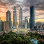 Kuala Lumpur skyline with Petronas Towers at sunset and lush city park in foreground