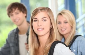 A photograph of one male and two female A Level students smiling at the camera.