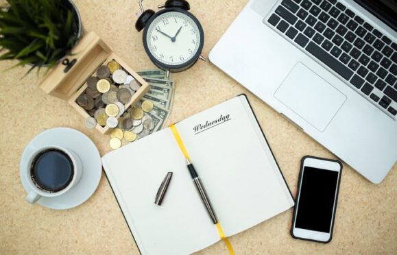 A laptop and notepad on a desk ready to be used.